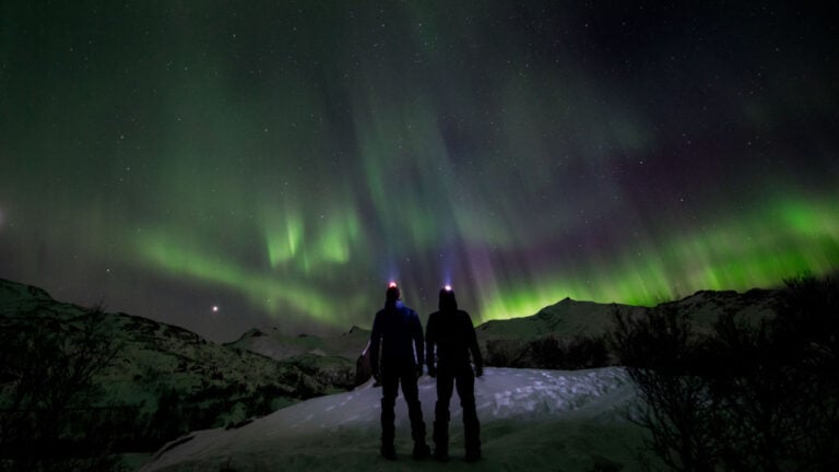 Deux personnes observant les aurores boréales en Norvège.