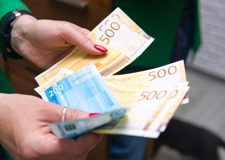 Billets de banque en couronnes norvégiennes dans la main d'une personne.