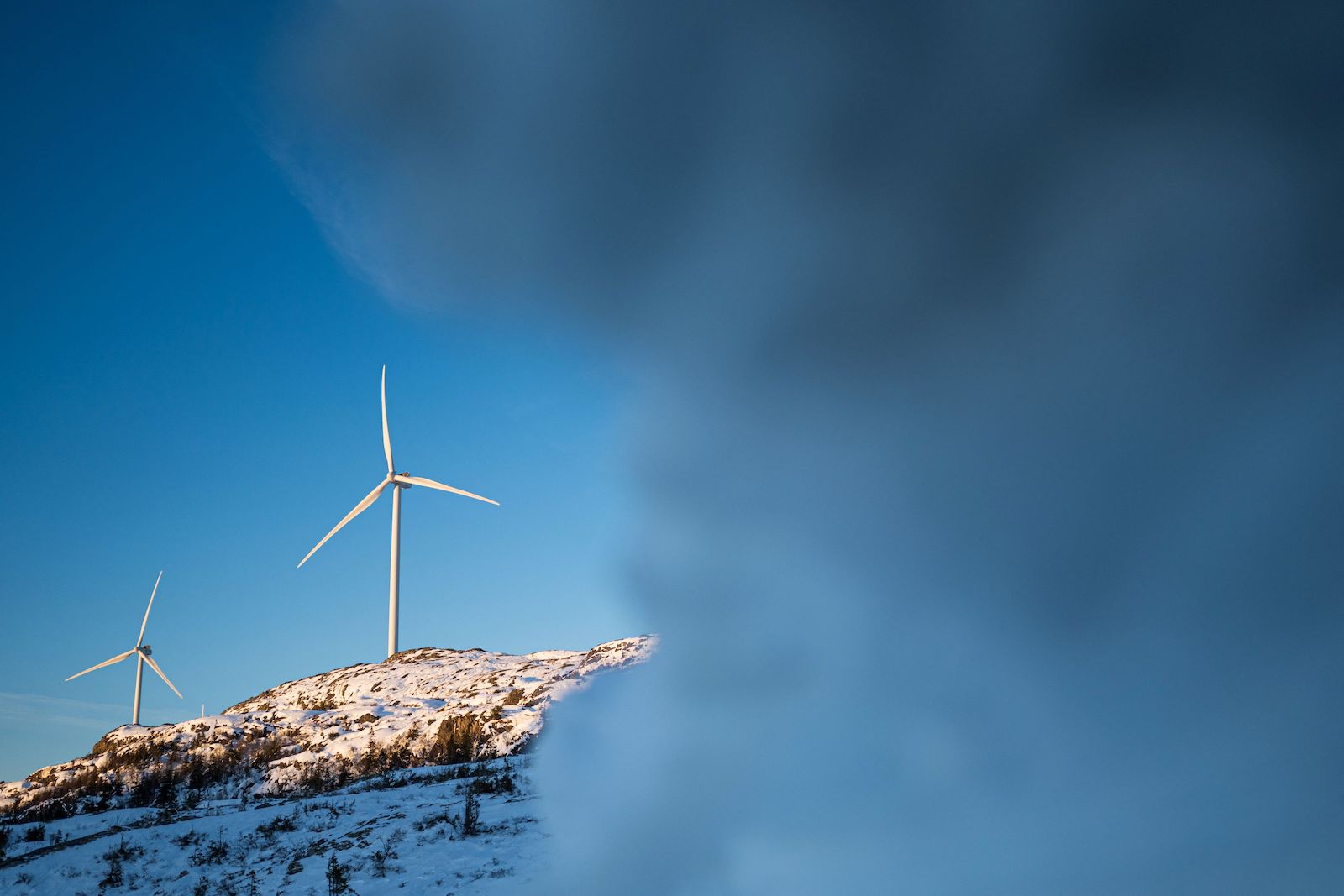 Le plus grand parc éolien de Norvège viole les droits des populations autochtones. Pourquoi les autorités ne prennent-elles pas de mesures ? 19 le brouillard masque les éoliennes sur une colline enneigée