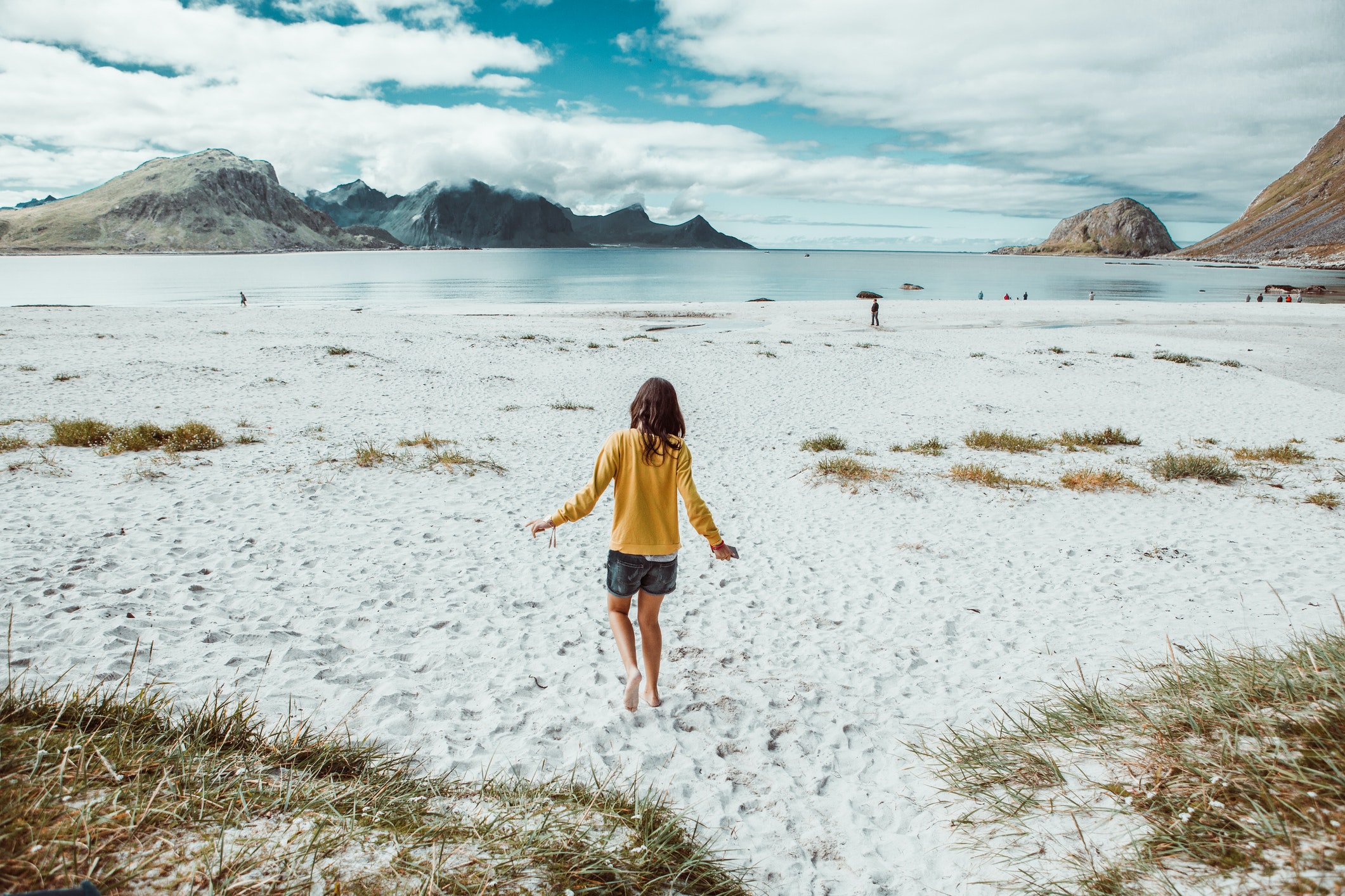 Image arrière d'un adolescent marchant seul sur une plage isolée en Norvège.