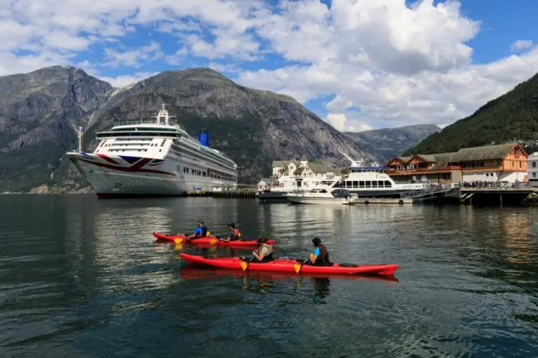 Comment organiser la meilleure croisière dans les Fjords norvégiens ? 46 Touristes faisant du kayak près du bateau de croisière P&O Aurora à Eidfjord. Photo : Eleanor Scriven / Shutterstock.com.