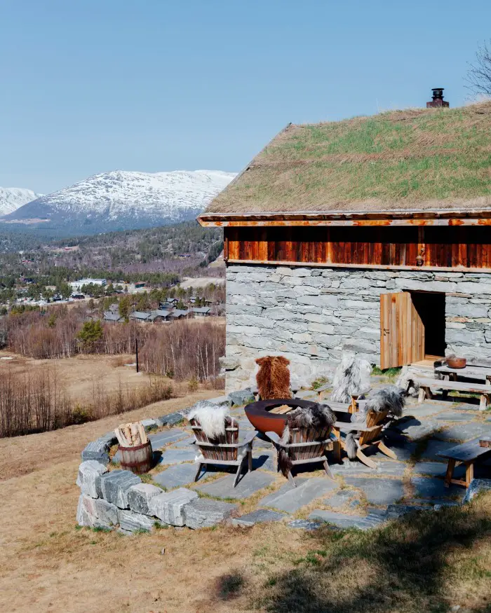Chez les Flakks, dans les fjords de l'ouest de la Norvège 42 Chaises Adirondack locales autour d'un foyer Der Feuerrige à l'extérieur de la grange restaurée.