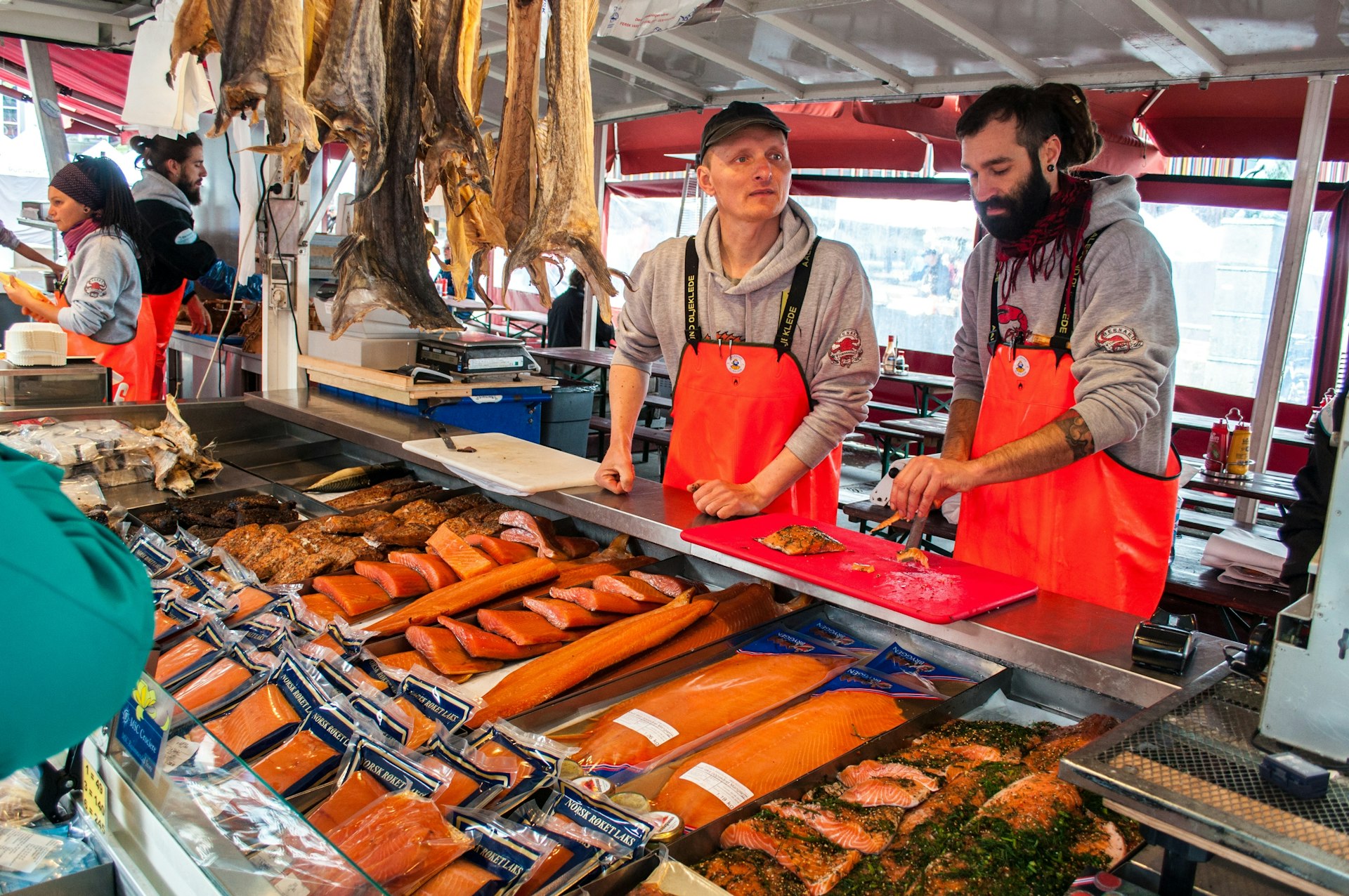 Deux vendeurs de poisson frais au marché aux poissons, en tablier rouge, à Begren.