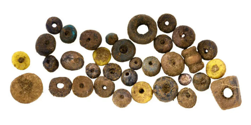 Une « pierre de vulve » et des bijoux en pièces de monnaie parmi des trésors remarquables découverts sur un site funéraire viking en Norvège 22 Perles excavées à fond blanc.