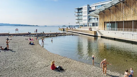 Alamy Personnes sur une petite plage dans le quartier d'Aker Brygge au centre d'Oslo Norvège (Crédit : Alamy)