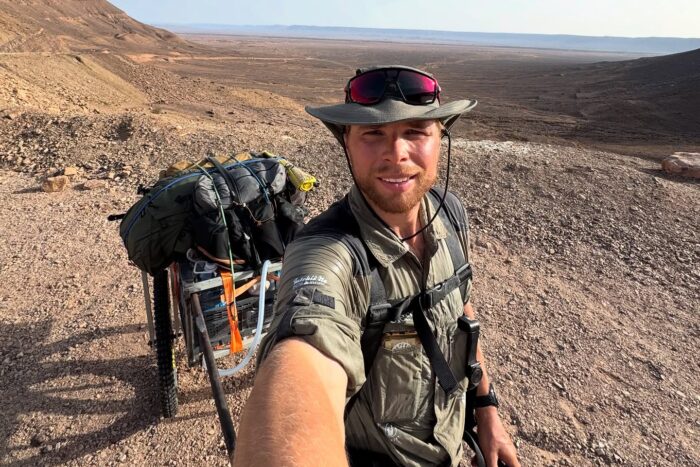 Un aventurier traverse le désert marocain lors d'une expédition de la Norvège à l'Amazonie " Explorersweb 13 selfie d'un randonneur tirant un chariot