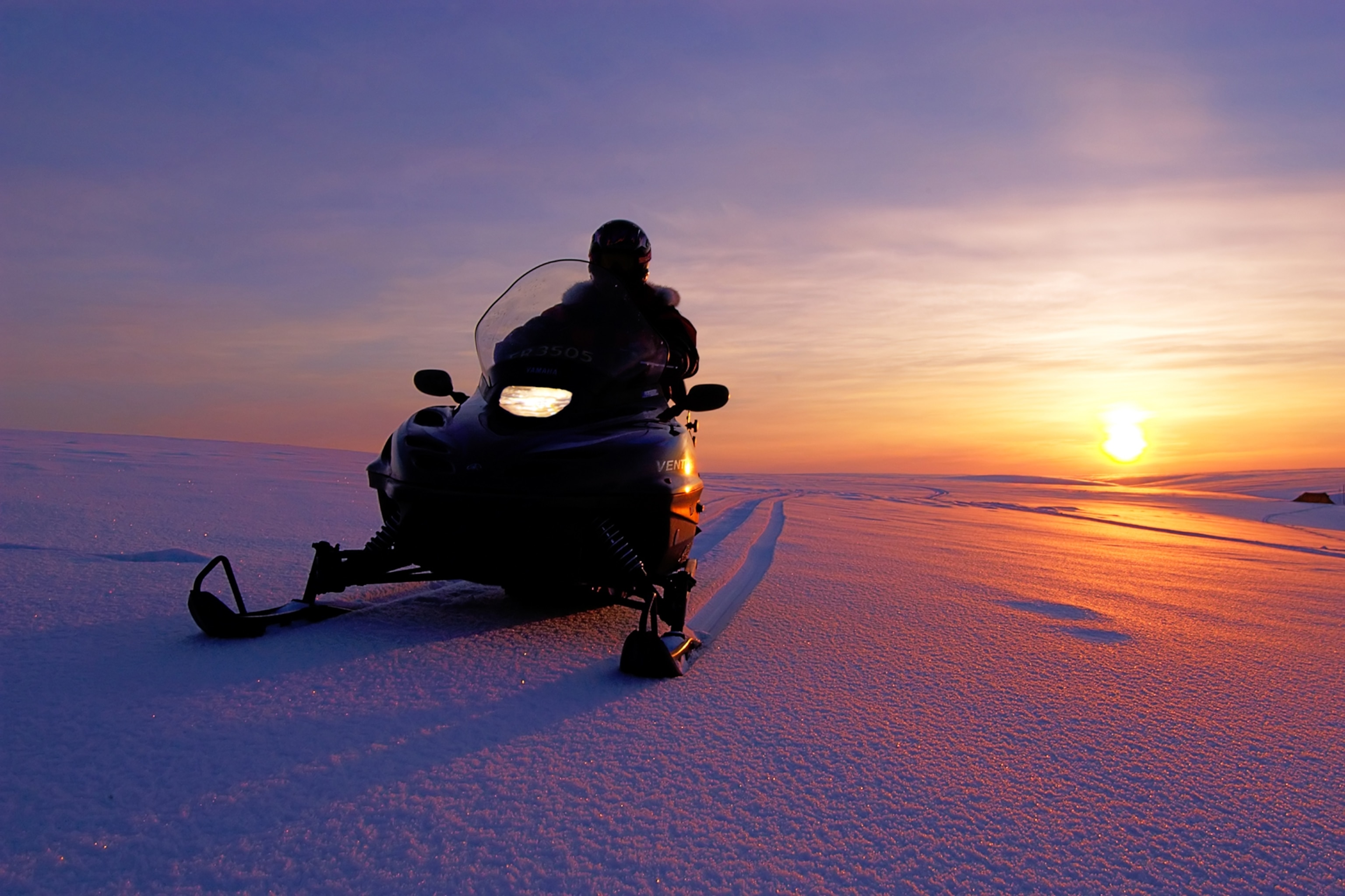 L'hiver dans le nord de la Norvège est l'aventure ultime - voici pourquoi 12 Un motoneigiste s'arrête dans la neige au lever du soleil dans le nord de la Norvège.