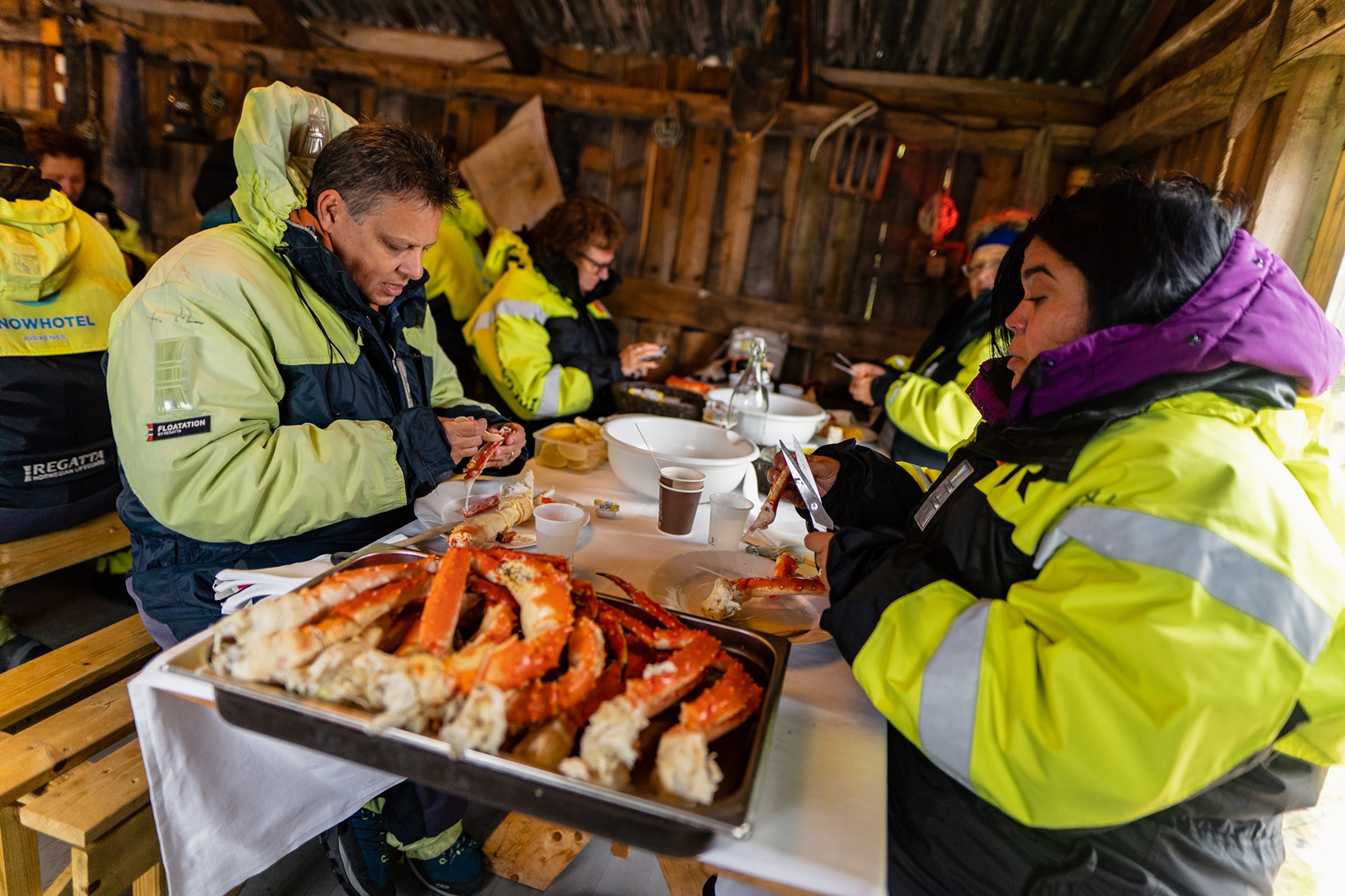 L'hiver dans le nord de la Norvège est l'aventure ultime - voici pourquoi 13 Des touristes vêtus de manteaux chauds ouvrent des carapaces de crabe royal fraîchement pêché à Kirkenes.
