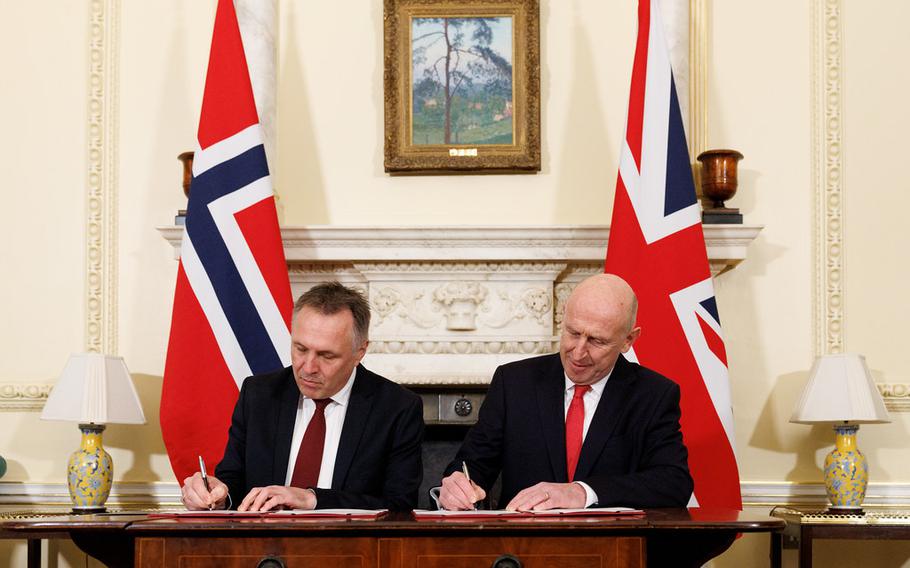 Le Royaume-Uni et la Norvège concluent un nouveau pacte de défense pour contrer la menace sous-marine russe dans l'Atlantique Nord 7 Deux hommes s'assoient l'un à côté de l'autre et signent un accord.