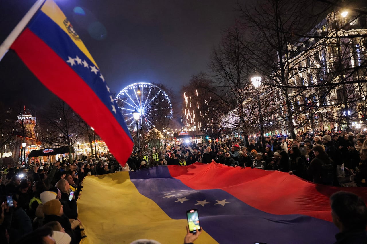 Le chef de l'opposition vénézuélienne, M. Machado, salue ses partisans en Norvège après la cérémonie du prix Nobel 11 Un drapeau vénézuélien porté dans la rue la nuit