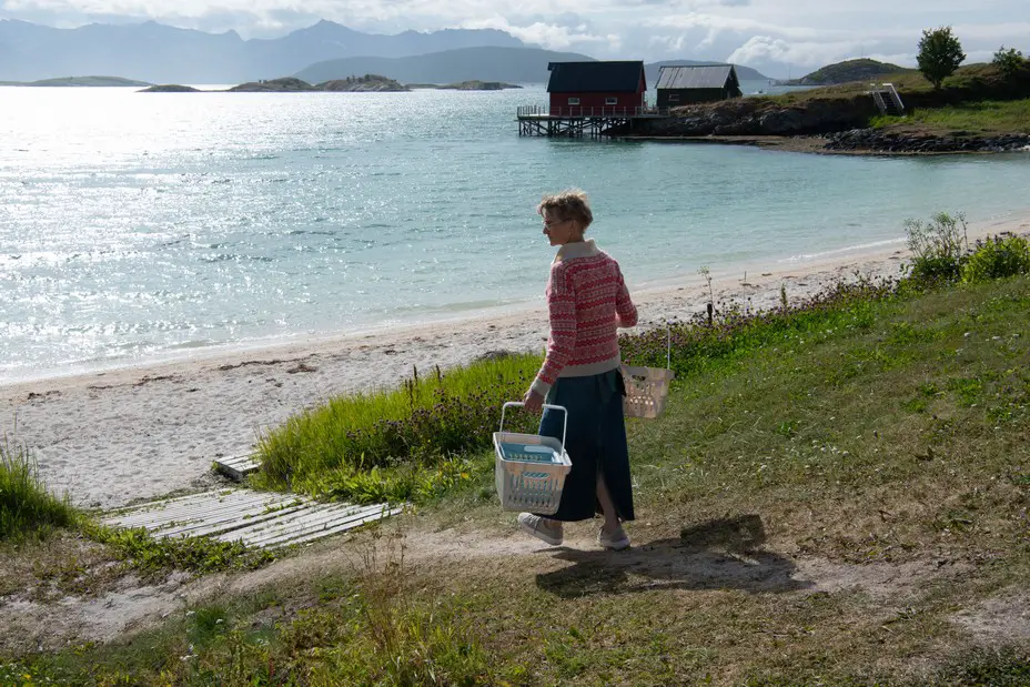 L'île sans temps - The Atlantic 30 Photographie couleur d'une femme portant de grands paniers tout en marchant vers la plage.