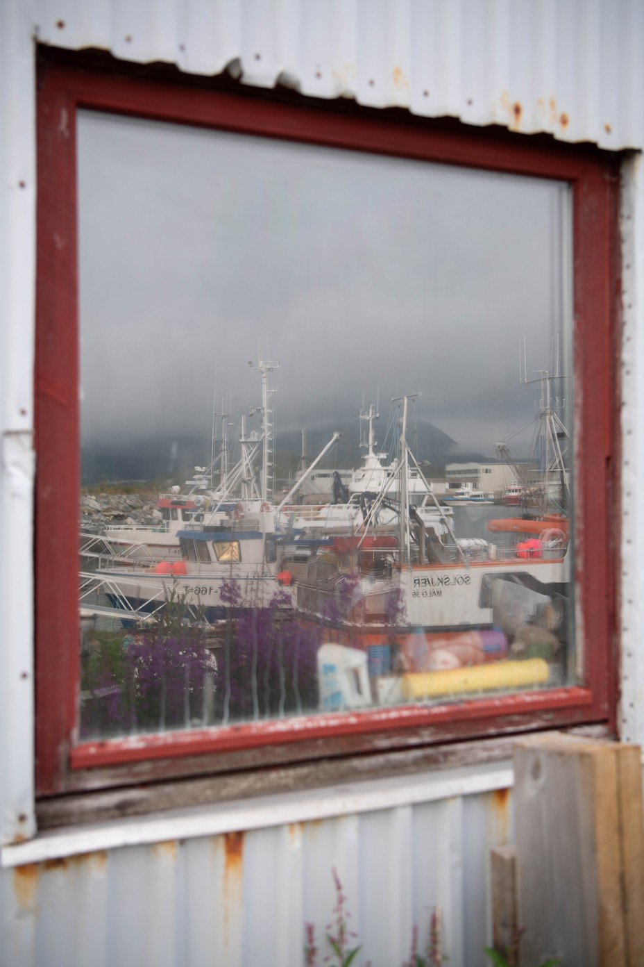 L'île sans temps - The Atlantic 31 Photographie couleur de bateaux de pêche se reflétant dans la fenêtre d'un bâtiment.