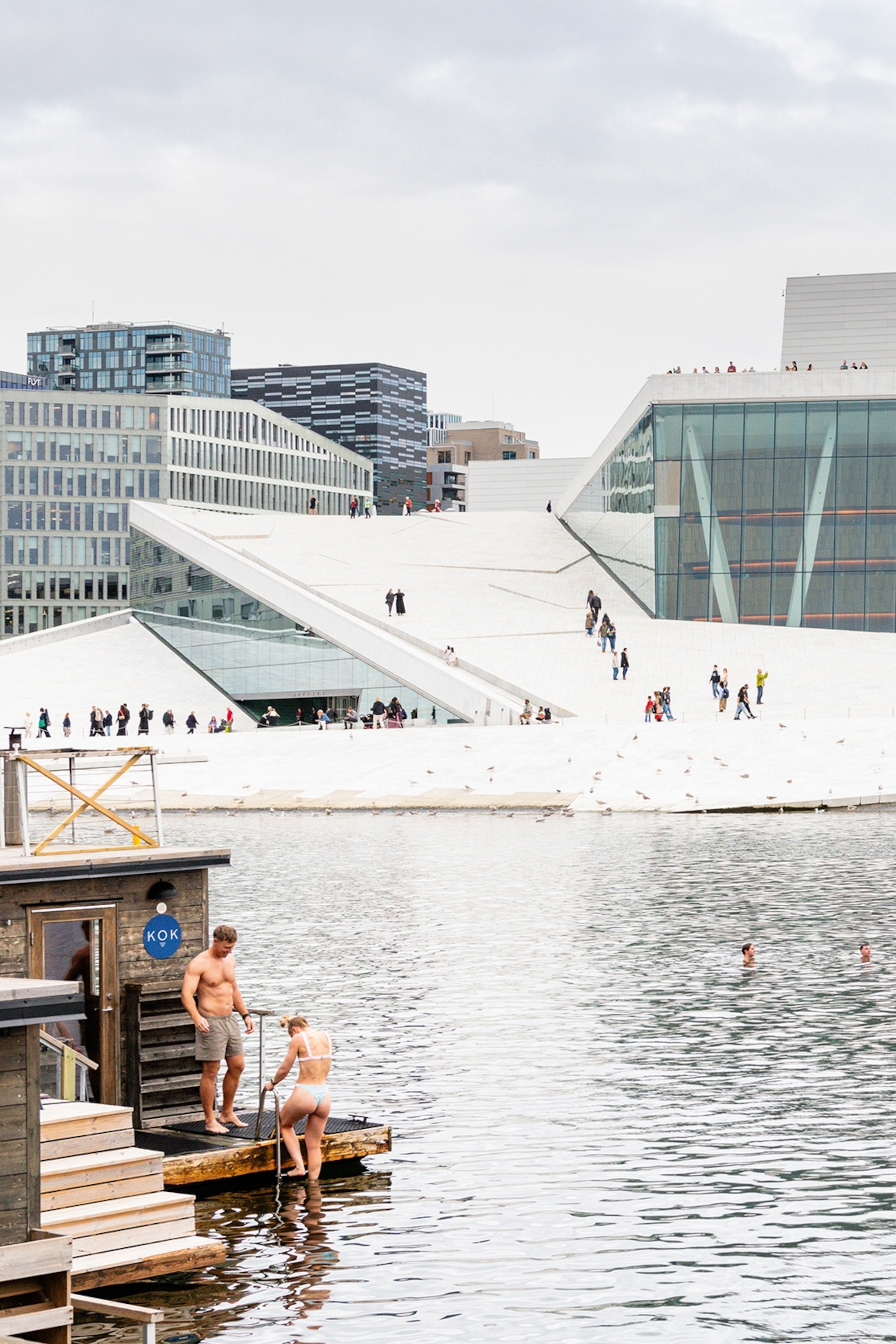 Oslo est la capitale norvégienne de la créativité — et le véritable berceau du street art 11 Des gens se baignant sur la promenade du port par une journée nuageuse.