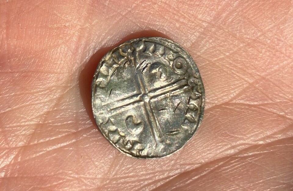 Découverte du plus grand trésor viking de Norvège, composé de 3 000 pièces d'argent : « Vraiment exceptionnel » 27 Petite pièce d'argent avec un motif en forme de croix tenue dans une main ouverte